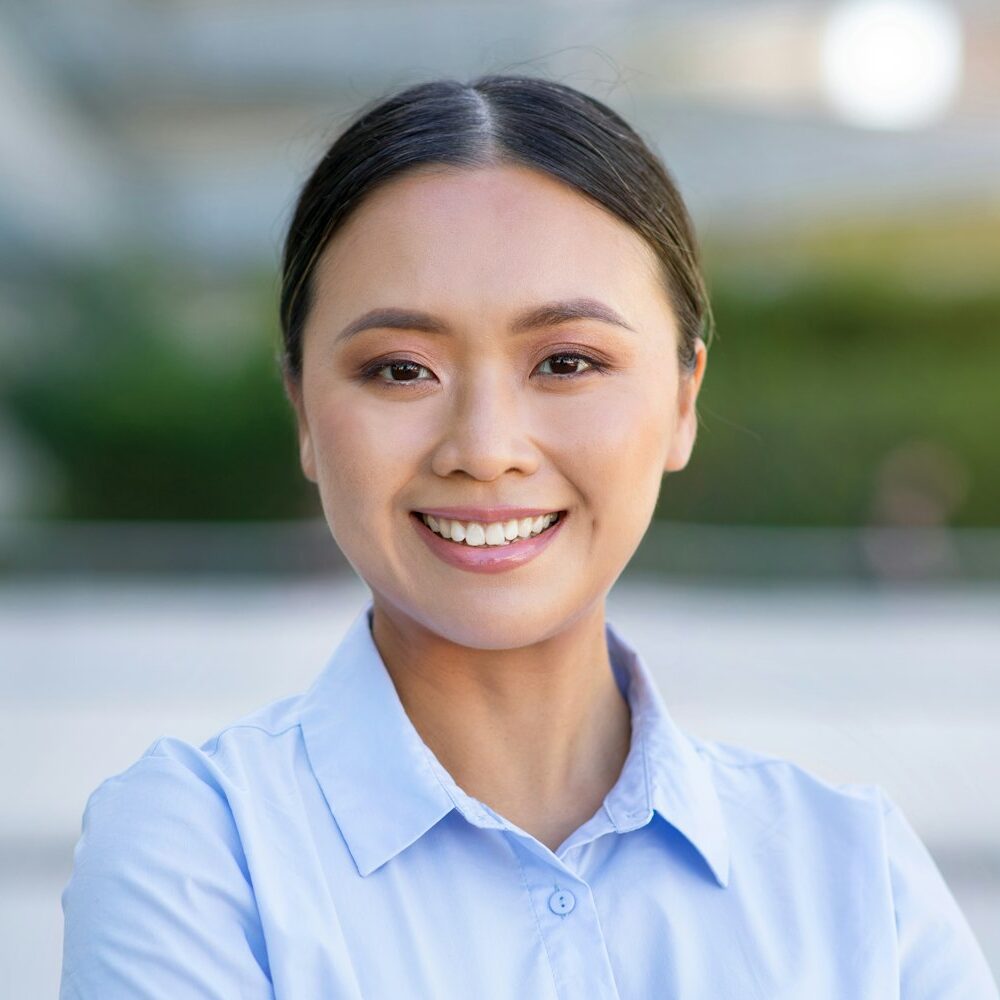 Portrait Of Confident Young Asian Businesswoman Standing In Urban Area